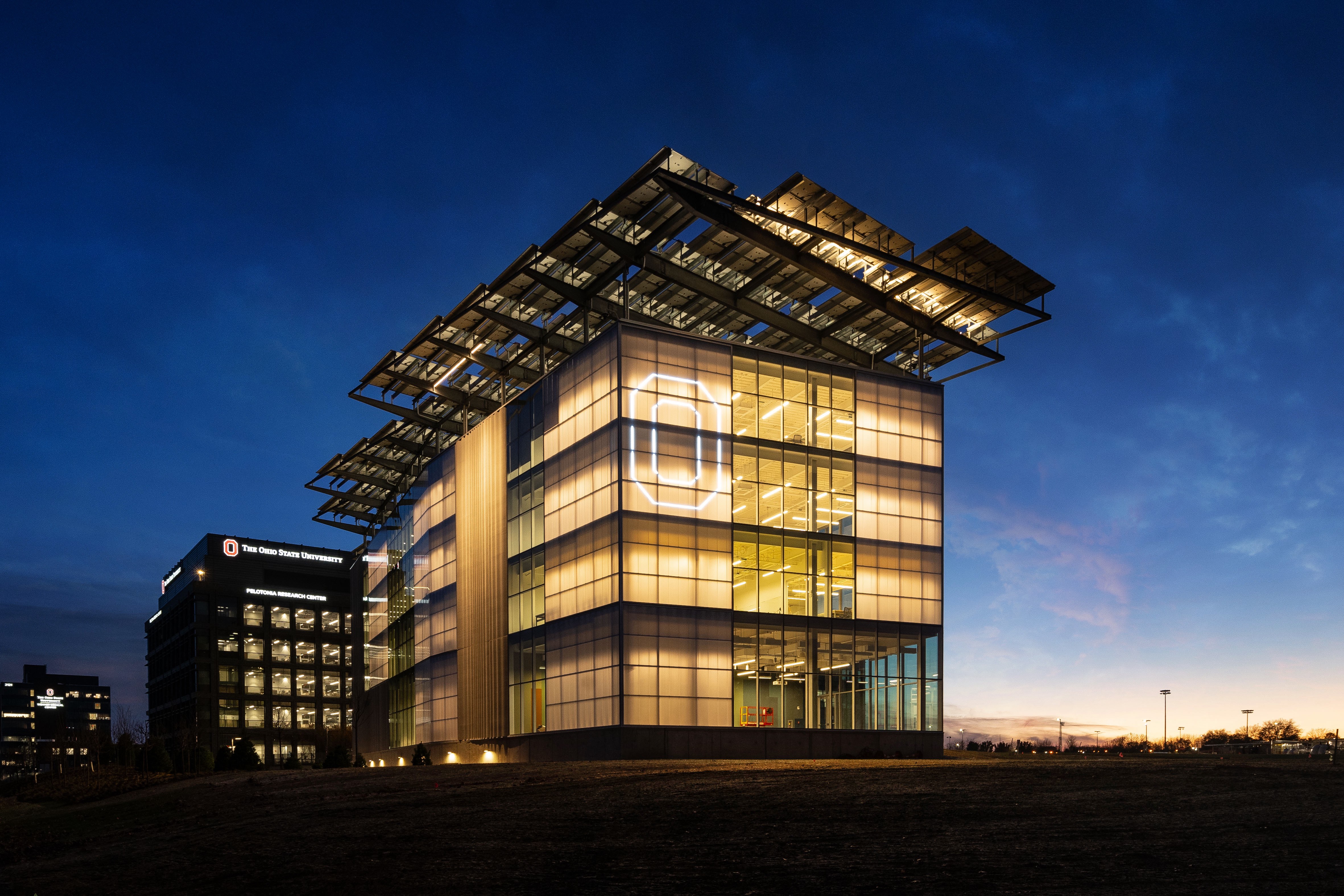 A view of the EAIC at night with a large Block O on the side of the building.