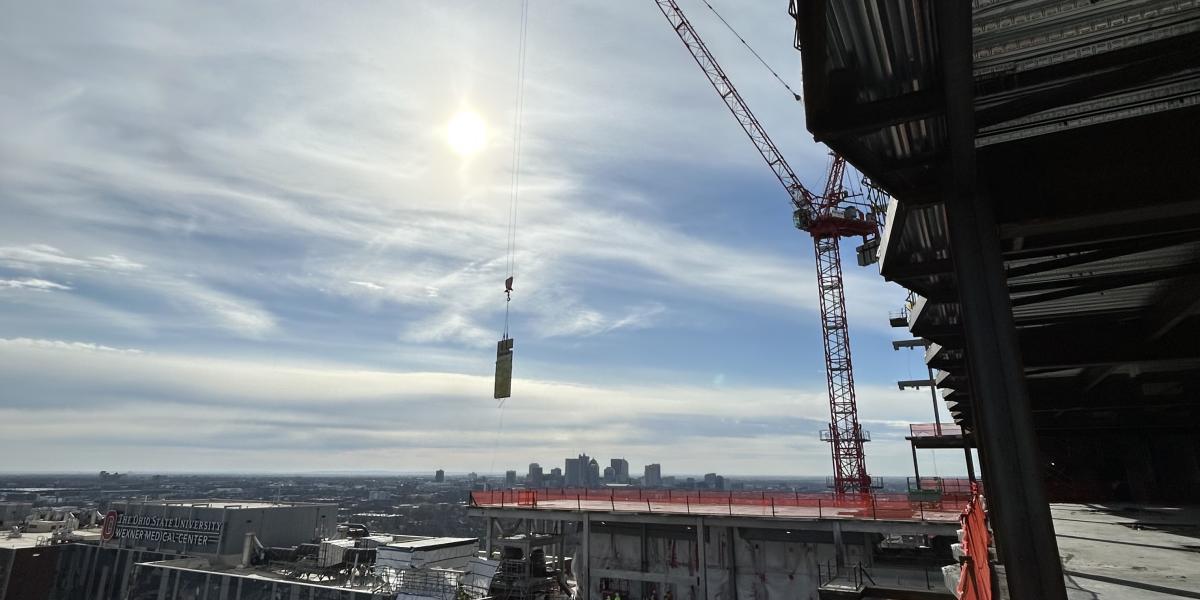 Panel being held in the sky by the crane. 