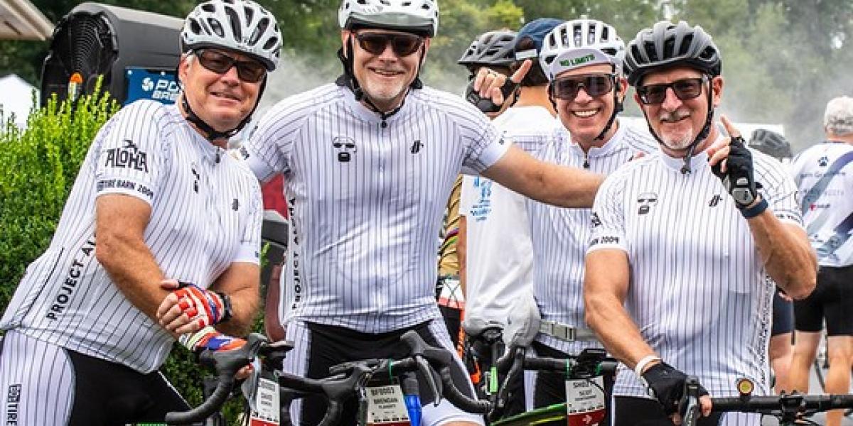 Four Pelotonia riders sitting on their bicycles smiling