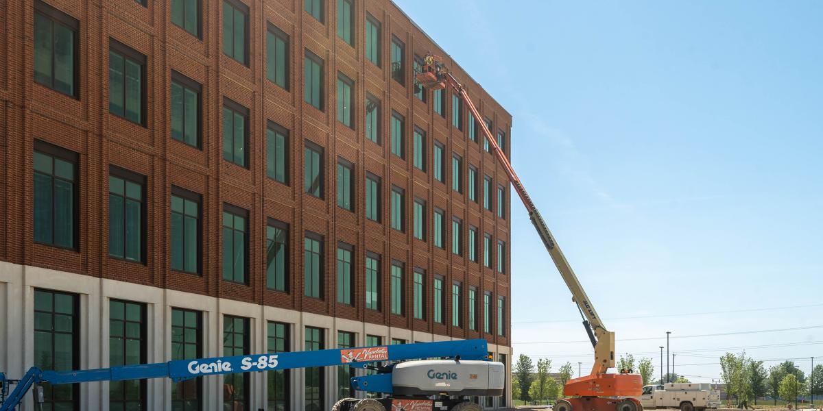 Crews are seen working on the exterior of the brick building.