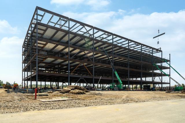 An exterior view of the medical office building. A crane can be seen on the right side of the building.