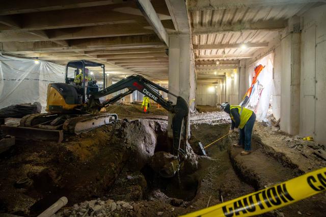 Crews digging a large hole.