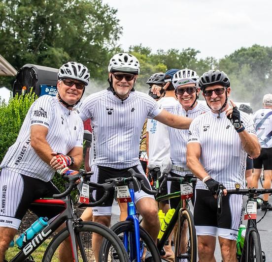 Four Pelotonia riders sitting on their bicycles smiling