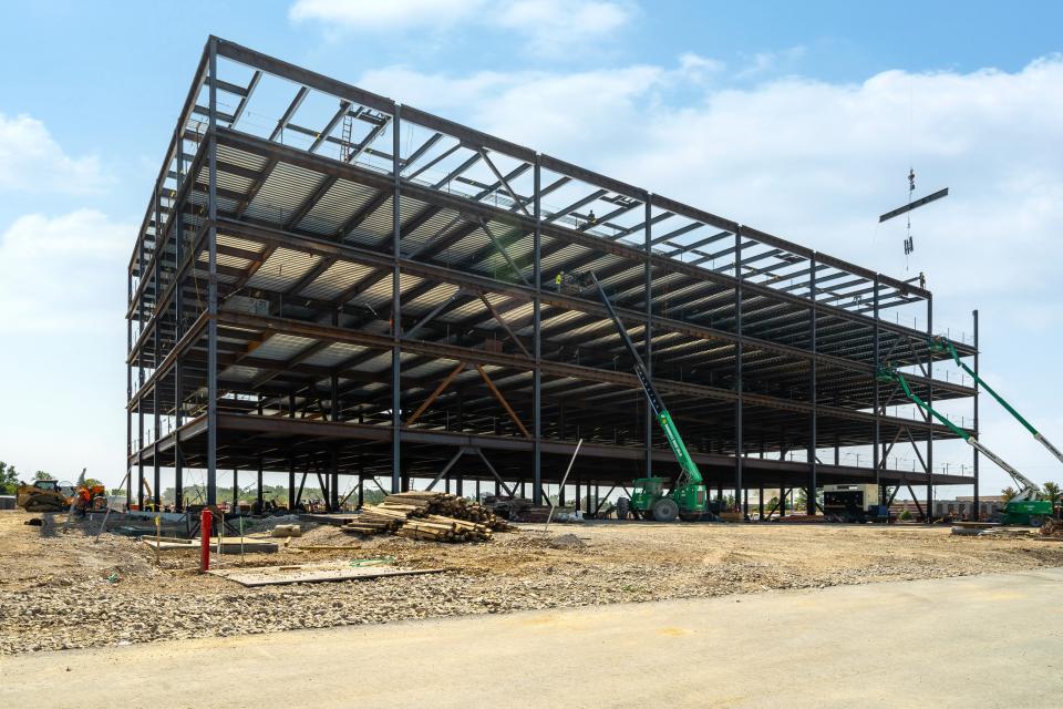 An exterior view of the medical office building. A crane can be seen on the right side of the building.