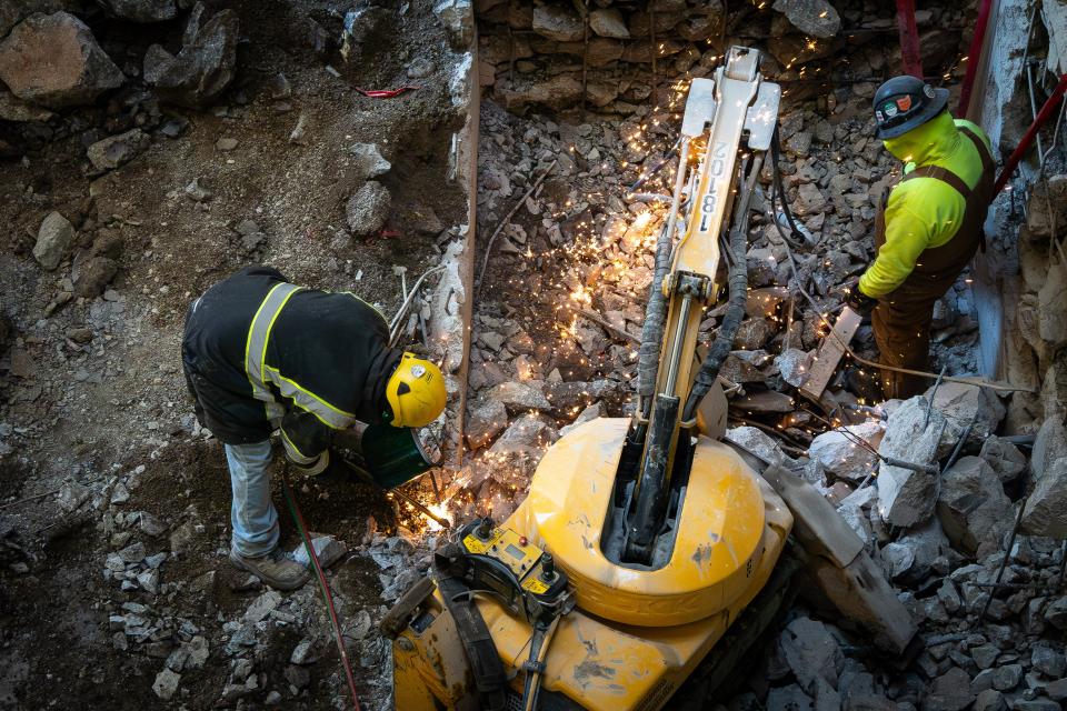 Two workers using the Brokk.