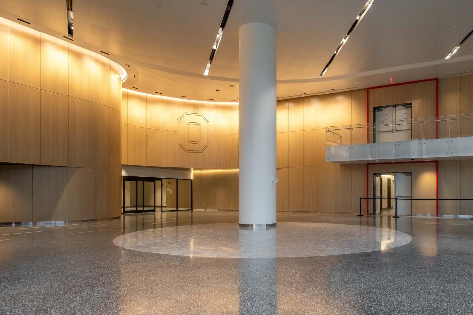 A view of the lobby where Terrazzo floors are seen finished with a large Block O on wood near the ceiling.