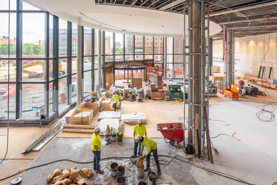 A view of the main lobby where crews are working to install flooring.